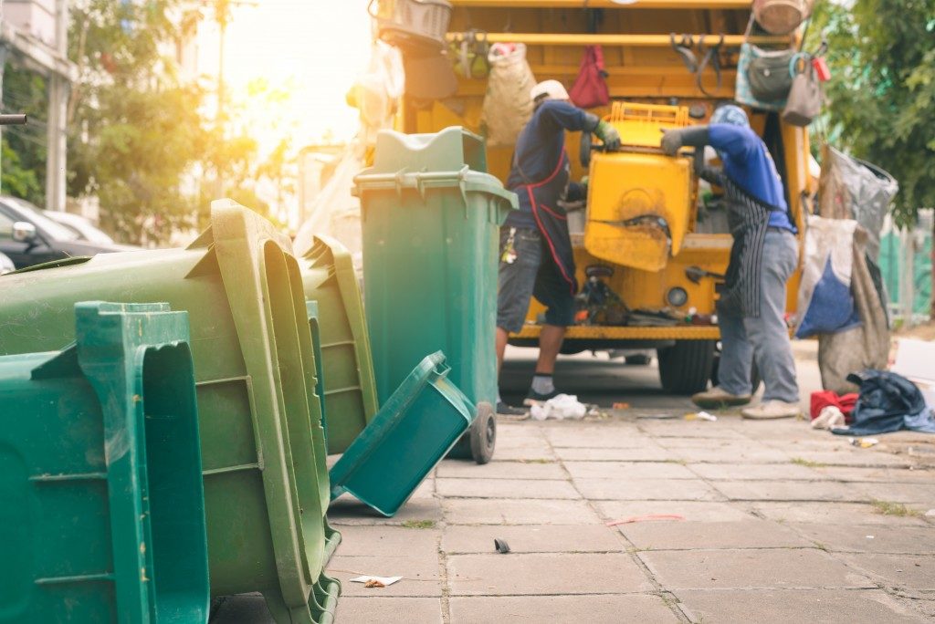 Workers collecting garbage from waste bins