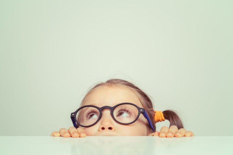 little girl with glasses looking up