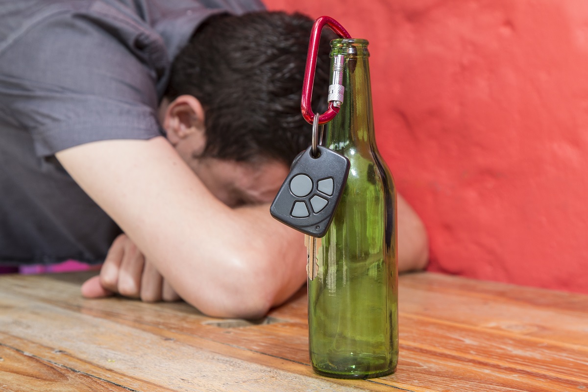 drunk man with car keys on bottle