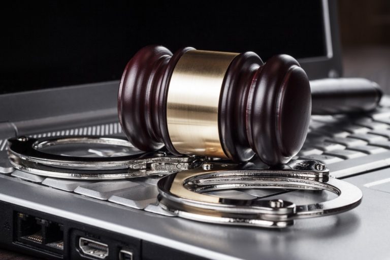 gavel and handcuffs on a keyboard