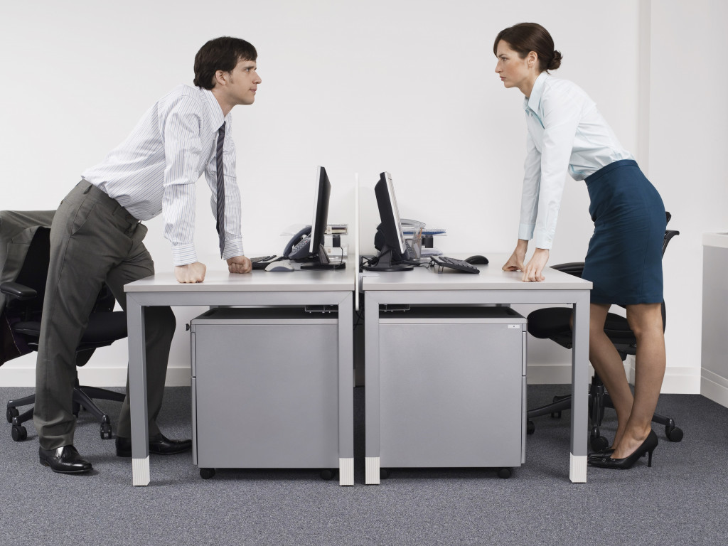 Side view of a male and female rival business colleagues in office