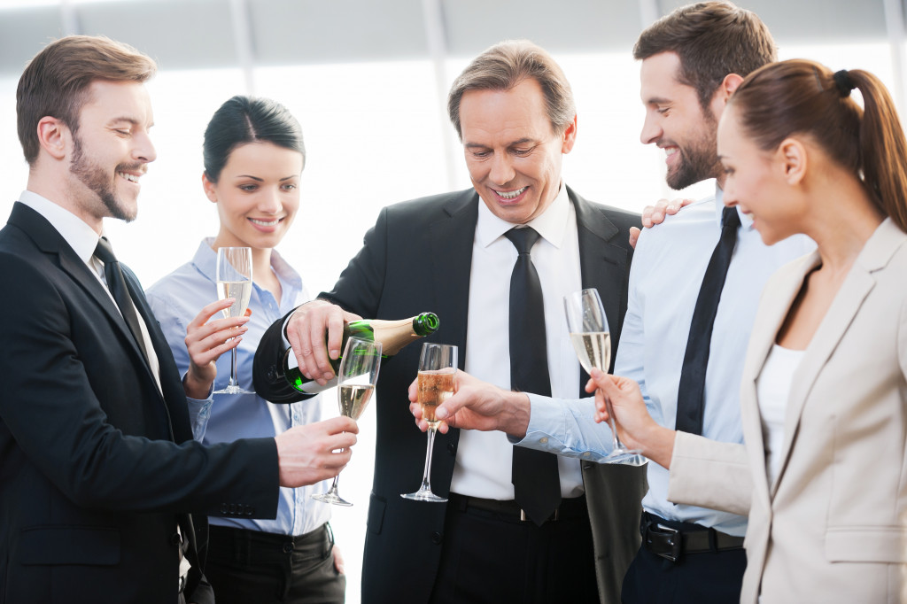 a businessman pouring drinks to guests